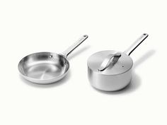 two stainless steel pots and pans on a white surface