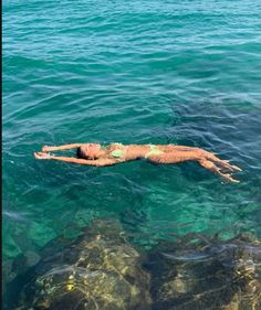 a man floating in the ocean on top of a body of water