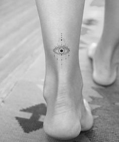 a woman's foot with an all seeing eye tattoo on her left side leg