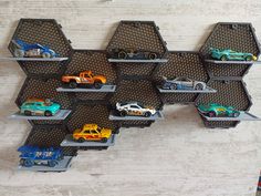 there are many toy cars on the shelves in this display case, which is made out of metal hexagons