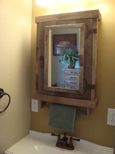 a bathroom sink with a mirror above it and a towel hanging on the wall next to it