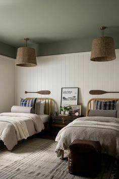 two beds in a room with lamps above them