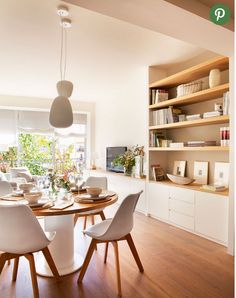 the dining room table is set with white chairs