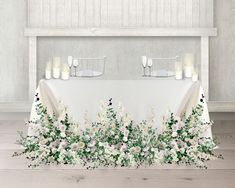 the table is covered with white flowers and candles