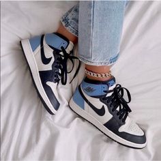 a pair of blue and white sneakers on top of a bed