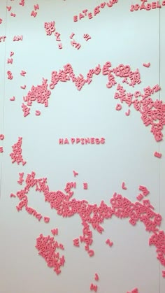 pink sprinkles are scattered on a white surface with the words happiness spelled in it