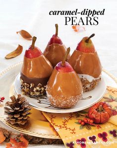 caramel - dipped pears on a plate with pine cones and autumn decorations around them