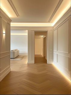 an empty room with white walls and wood flooring is lit by recessed lighting