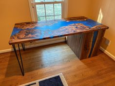 a wooden table sitting in front of a window on top of a hard wood floor