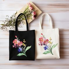 two bags with flowers painted on them sitting next to each other