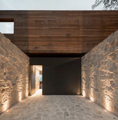 an instagramted photo of a house with stone walls and lights on the outside