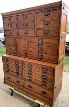 a large wooden dresser sitting on top of a sidewalk