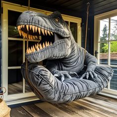 an inflatable dinosaur sitting on a porch swing with its mouth open and teeth out