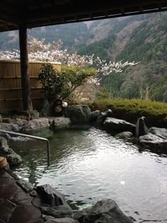 an outdoor hot tub surrounded by rocks and trees