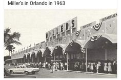 an old black and white photo of people in front of a store with cars parked outside