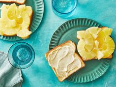 two pieces of bread with peanut butter and pineapple on them sitting next to glasses