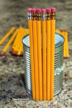 four yellow pencils sitting in a tin on top of a counter next to two empty cans