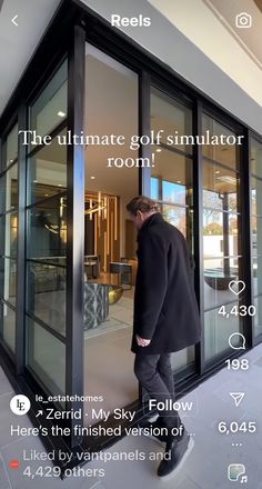 a man in a black coat is looking into a room with glass doors and the caption reads, the ultimate golf simulator room