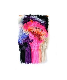 a multicolored rug with fringes hanging on a wall in front of a white background