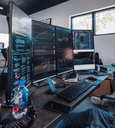 three computer monitors sitting on top of a desk next to a keyboard and monitor screen