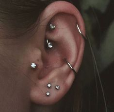 a woman's ear has three piercings on it