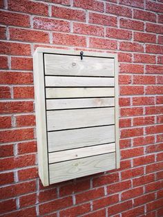 a wooden sign mounted to the side of a brick wall next to a red brick wall