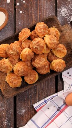 a wooden tray filled with pastries on top of a table