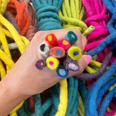 a person's hand with colorful yarn on it