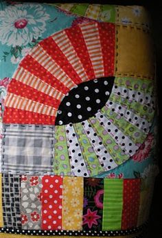 a colorful patchwork pillow with a decorative fan on it's front end and sides