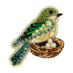 a bird brooch with beads and pearls on it