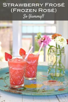 two glasses filled with watermelon and strawberries on top of a blue tray