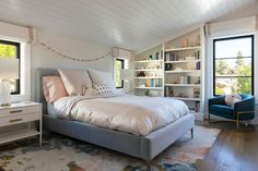 a bedroom with a bed, chair and bookcases