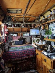 a bed sitting in the middle of a room next to a tv on top of a wooden shelf