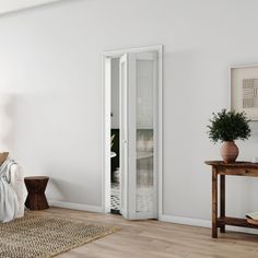 a bedroom with white walls and wooden floors