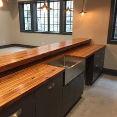 an empty kitchen with wooden counter tops and stainless steel sinks