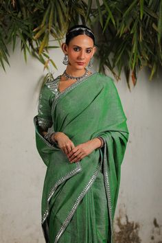 Step into timeless elegance with this handwoven cotton & zari sari, featuring a hand-embroidered border in silver. This exquisite piece is complemented by a matching hand-embroidered stitched blouse, exuding sophistication and charm. Perfect for making a statement at any special occasion with its refined detailing and classic design. Festive Embroidered Cotton Silk Pre-draped Saree, Traditional Cotton Silk Sharara With Embroidered Border, Festive Slub Silk Dupatta With Embroidered Border, Festive Tussar Silk Kurta With Embroidered Border, Festive Slub Silk Sets With Embroidered Border, Silver Pre-draped Saree For Eid, Festive Embroidered Pre-draped Cotton Silk Saree, Green Slub Silk Traditional Wear With Embroidered Border, Slub Silk Traditional Wear With Embroidered Border For Diwali