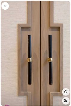 an open wooden door with two black handles and one gold handle on the bottom part