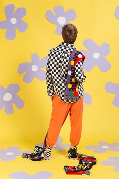 a young boy in an orange pants and checkered jacket