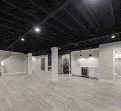 an empty room with wooden floors and white cabinets in the center is lit by recessed lights