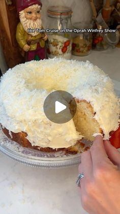 someone is cutting into a cake with white frosting