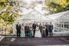 a group of people standing next to each other in front of a white building with glass walls