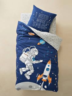 a child's bed with space themed comforter and pillows