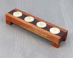 three candles are placed on a wooden stand