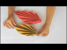 a woman holding a red and gold paper fan