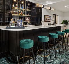 a bar with green velvet stools next to it