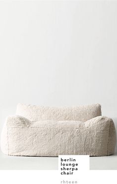 a white couch sitting on top of a floor next to a wall