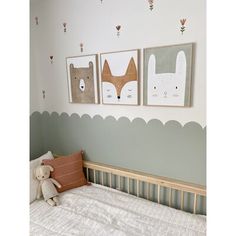 a baby's room with three pictures on the wall and a teddy bear in bed