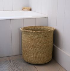 a basket sitting on the floor next to a bath tub