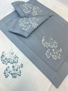 blue and white sheets with embroidered designs on them