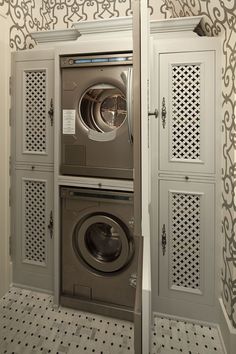 a washer and dryer in a room with patterned wall paper on the walls